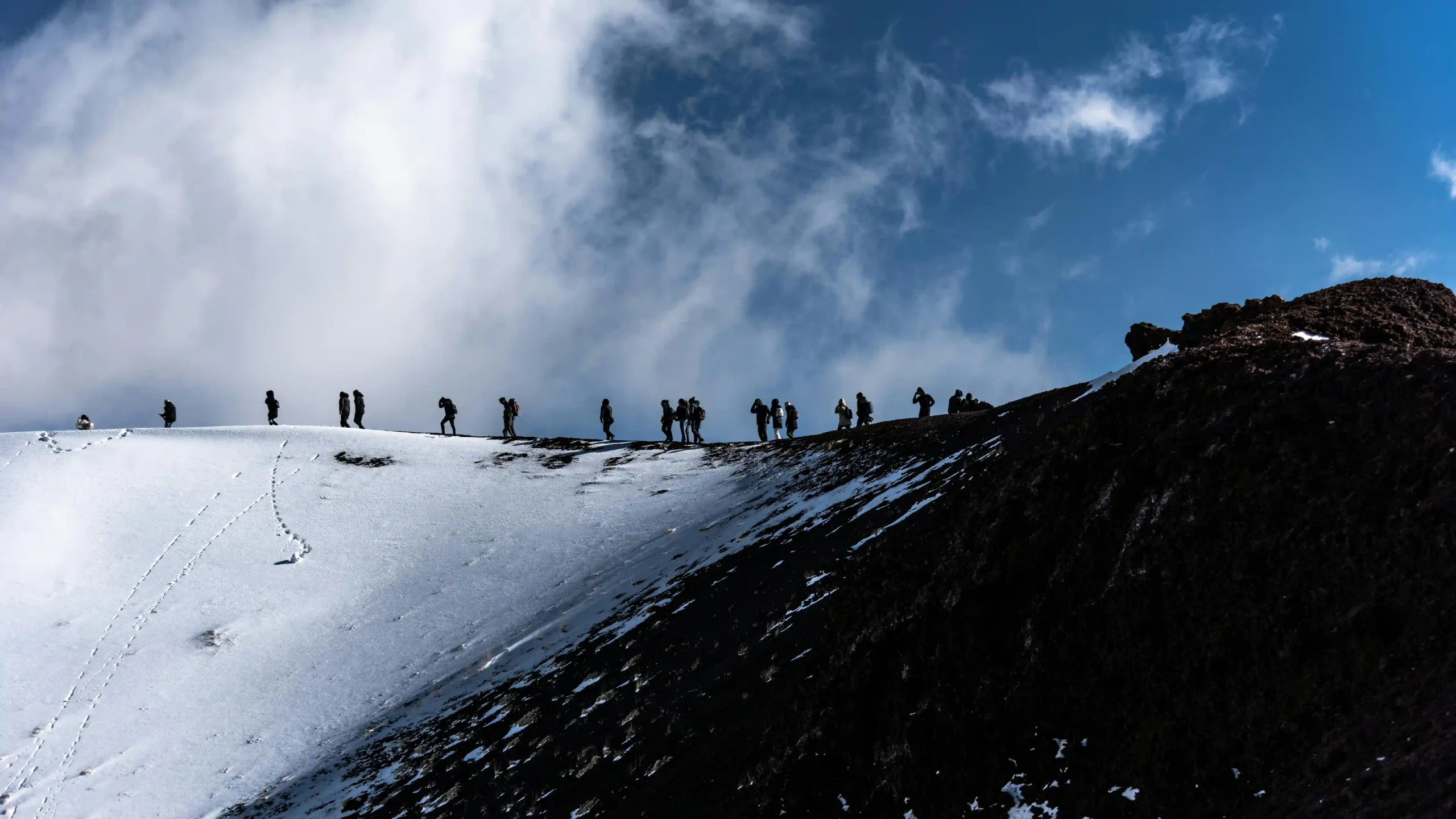 Randonneurs marchant sur la neige à Etna Nord
