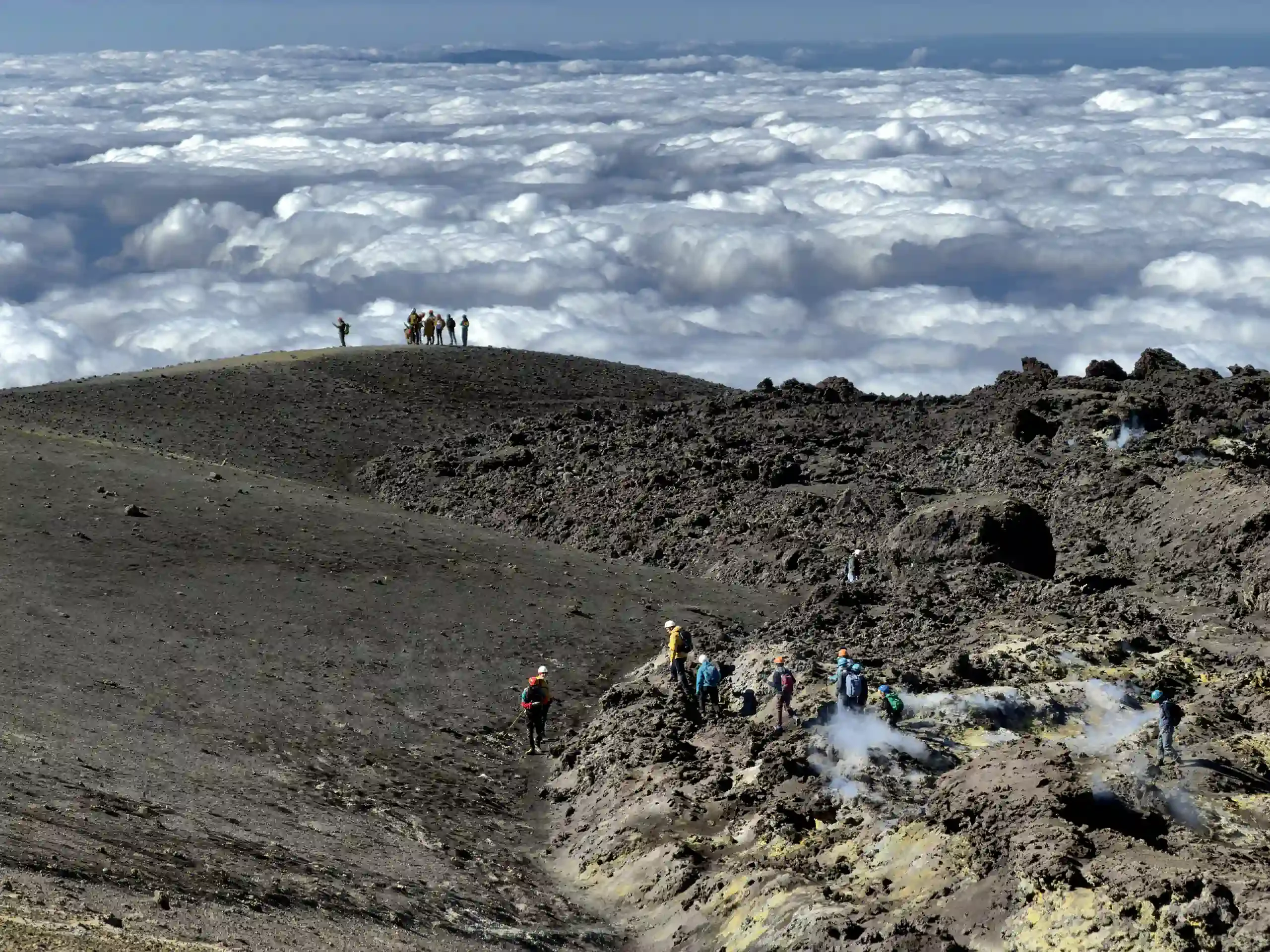 Etna topkraters excursie - Wandelaars op het topplateau boven de wolkenzee