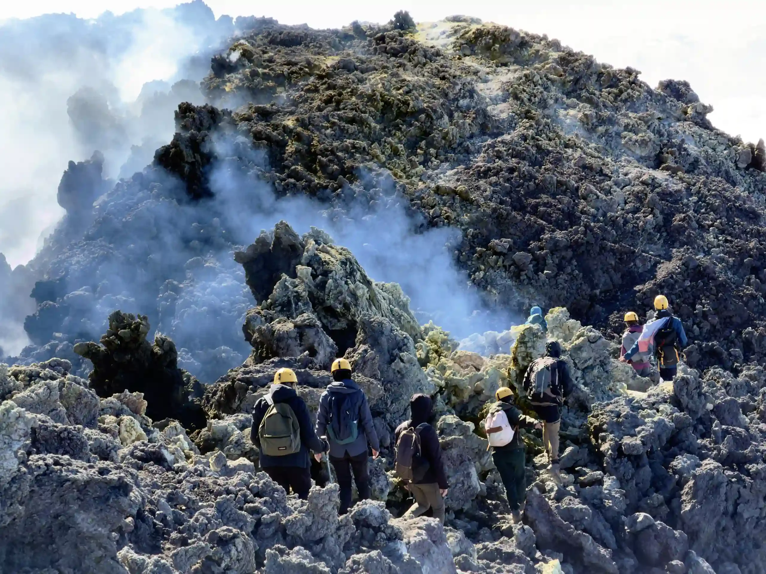 Etna topkraters excursie - Groep met helm en vulkanologische gids tussen de lavarotsen