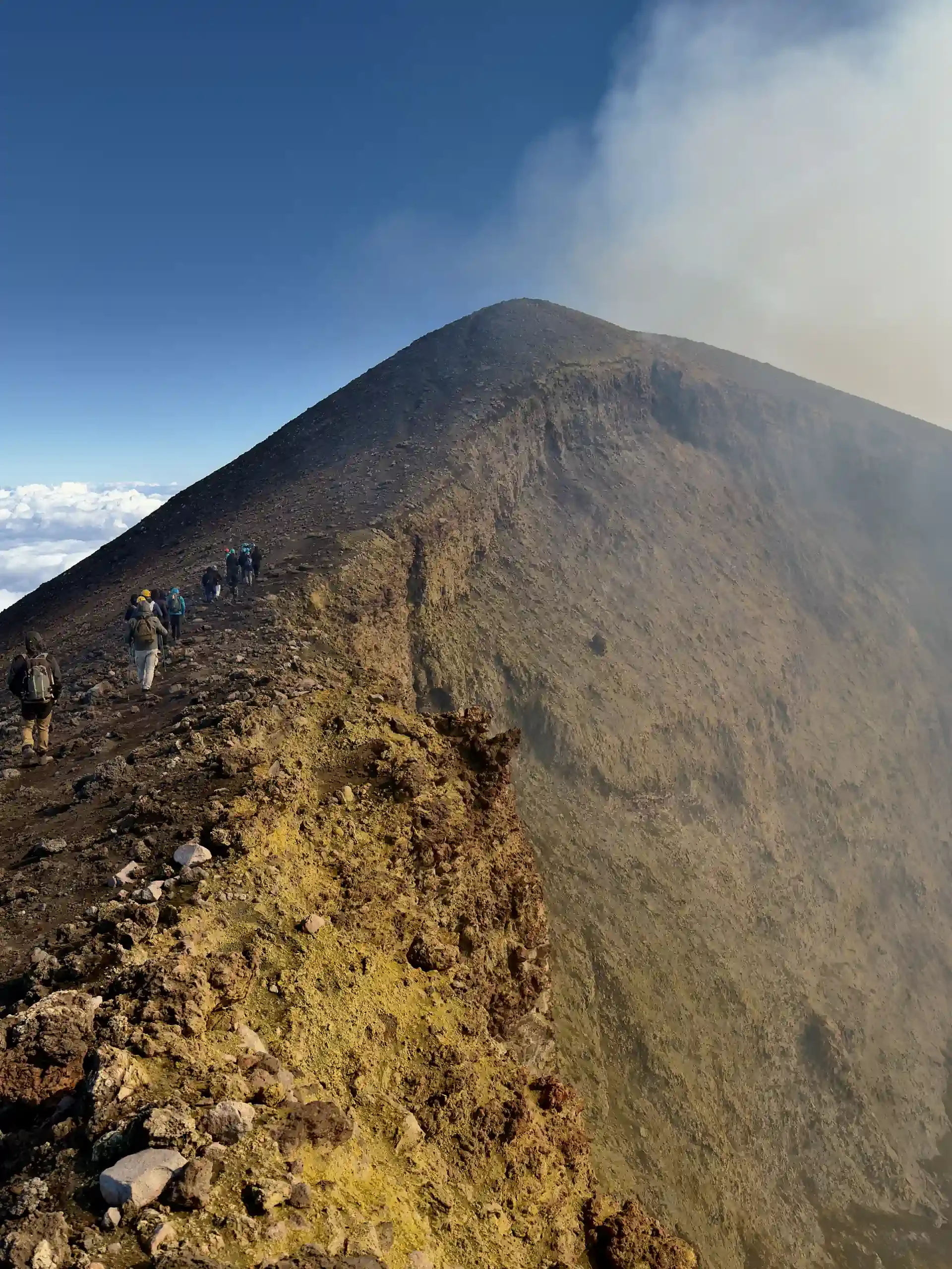 Etna topkraters excursie - Wandelaars op de rand van de Noordoostkrater boven de wolken